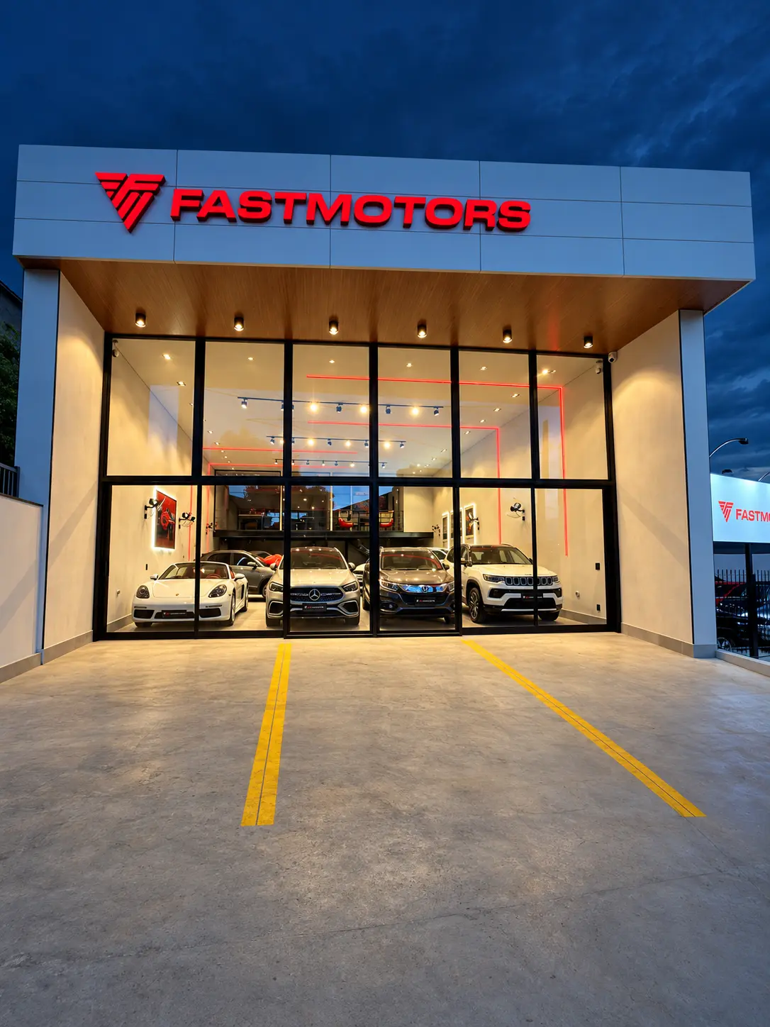 Fachada da FASTMOTORS iluminada à noite